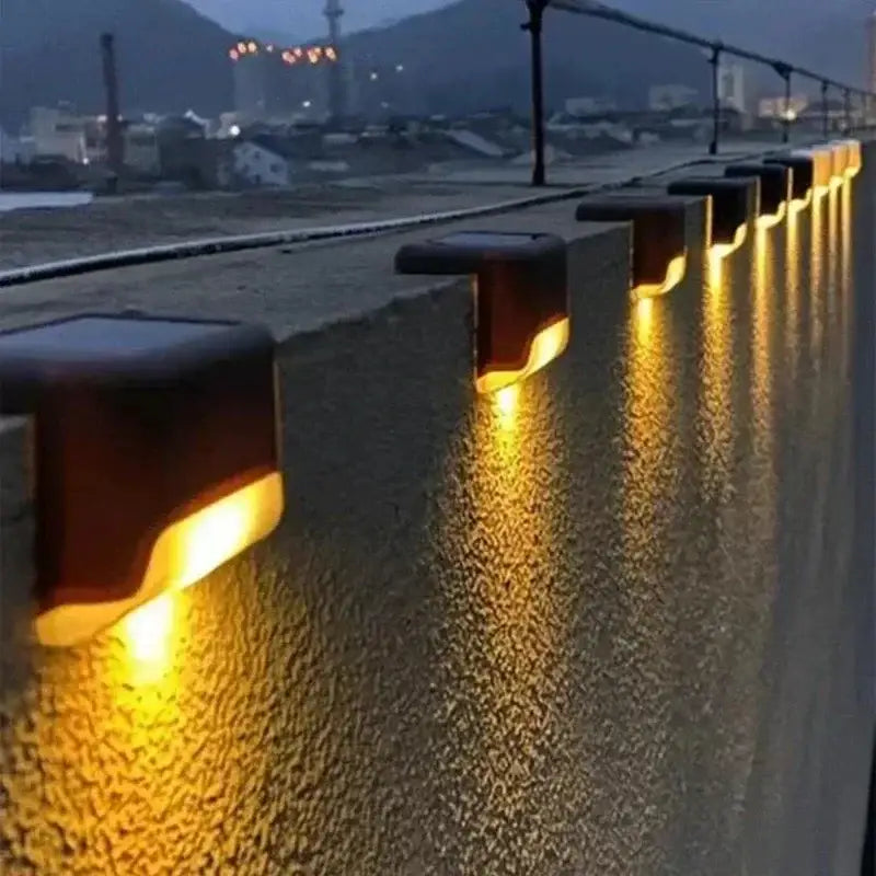 DecorBites™ solar led outdoor stair lights with warm yellow leds and dark brown plastic housing on concrete wall