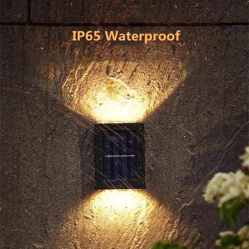 DecorBites™ solar led outdoor wall light with black rectangular design and warm lamp beads casting soft glow on stone surface