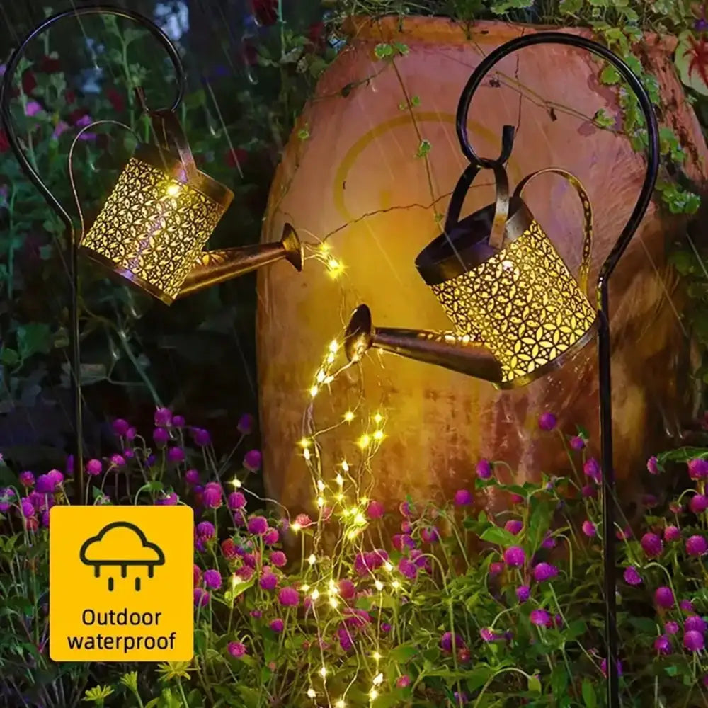 Two golden ornate metal solar watering can lights with intricate cut-out patterns and glowing led strings for outdoor decor