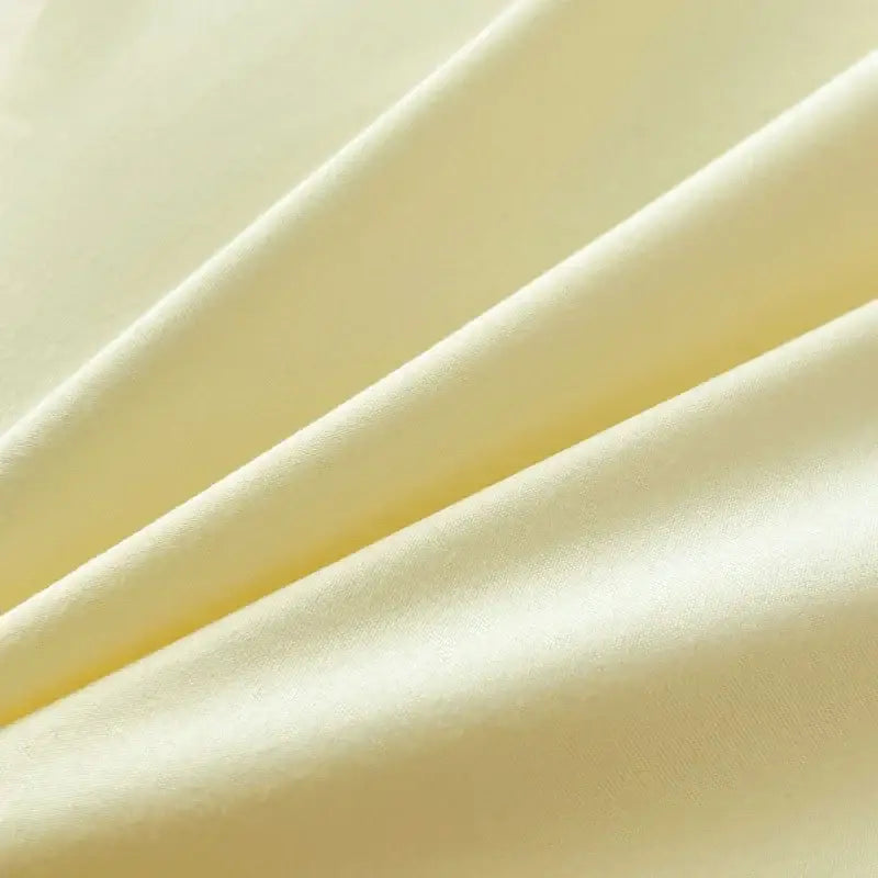 Soft pale yellow solid color brush fabric duvet cover with a smooth glossy finish in a decorbites bedding set