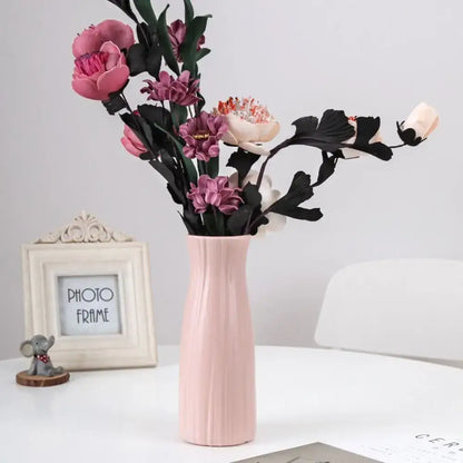 DecorBites solid color blush-pink plastic flower vase with vertical ridges holds pink and purple artificial flowers