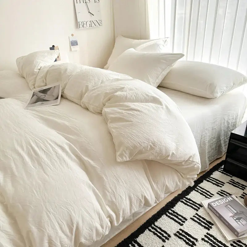 White solid cotton bedding set featuring a duvet cover and matching pillows neatly arranged on a bed by decorbites