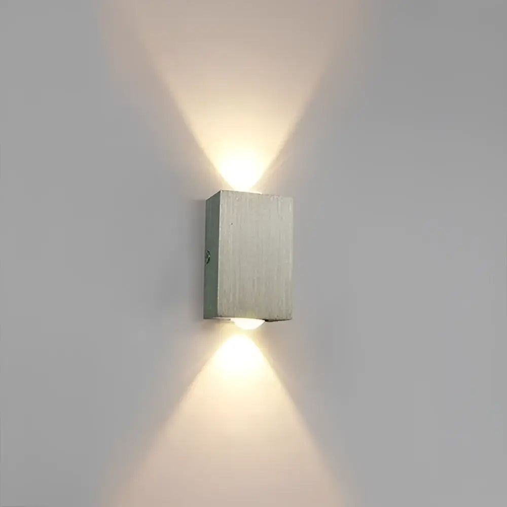 Modern brushed aluminum sphera wall sconces by decorbites with two angled lights casting warm illumination