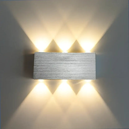 Silver rectangular decorbites sphera wall sconces with four warm LED lights casting geometric shadows