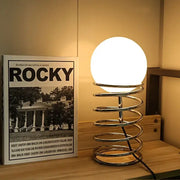Decorbites™ spring glass table lamp with glowing white globe and polished chrome spiral base for modern lighting