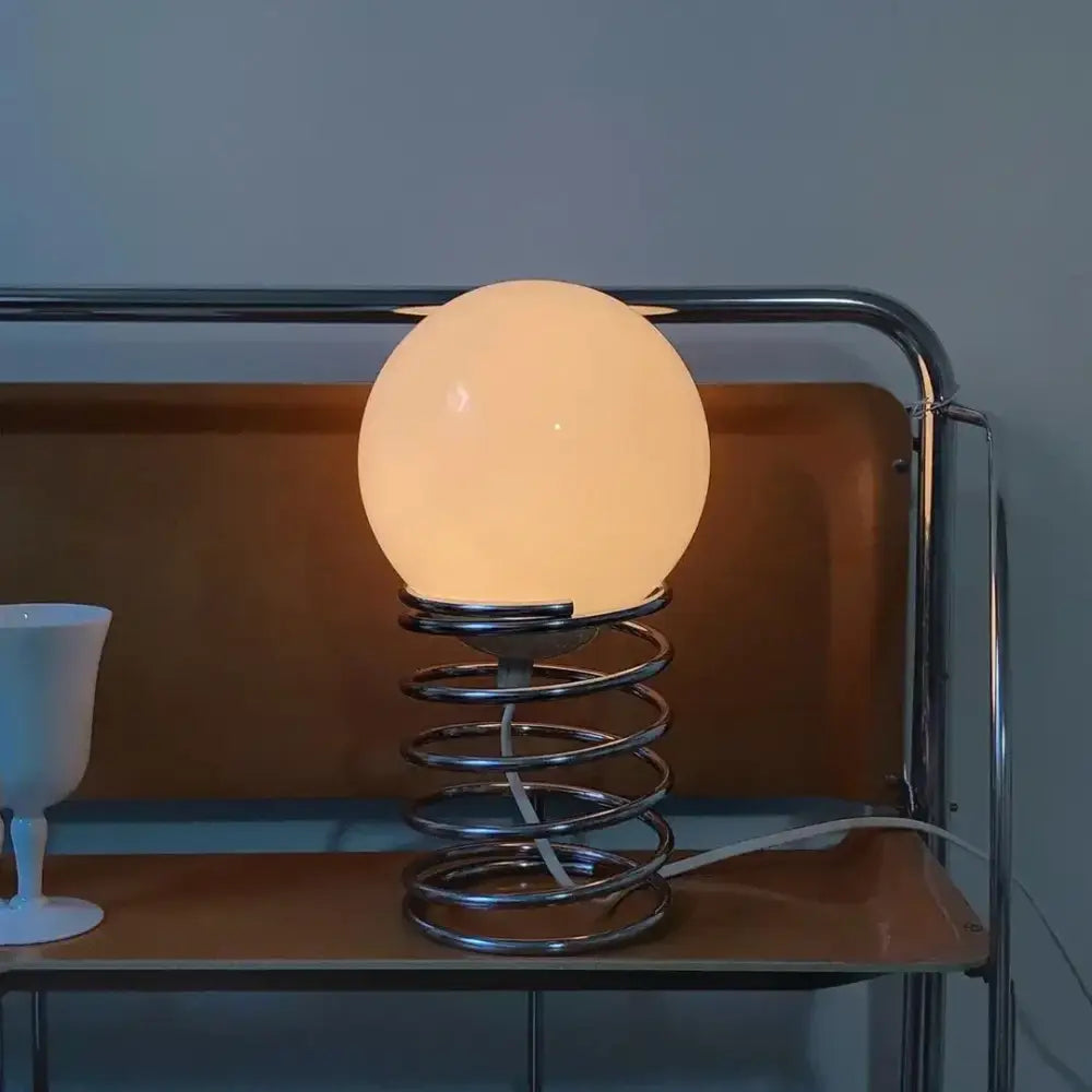 DecorBites™ spring glass table lamp with warm opaque white spherical glass shade and chrome spring base