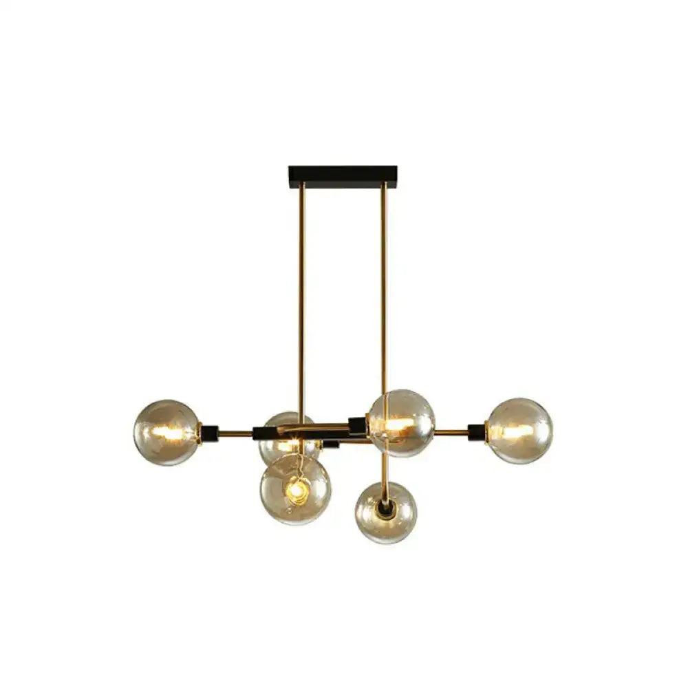 Modern brass and black sputnik hanging island light with six amber glass bulbs for dining room decor by DecorBites™