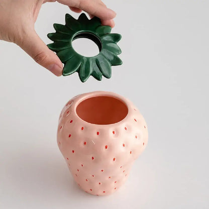 Pink ceramic strawberry shaped planter pot with green leafy lid by DecorBites™ for decorative use