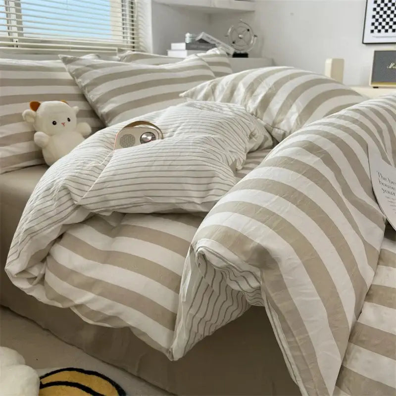 A cozy bed dressed in a cream and beige striped quilt set with pillowcases from decorbites bed sheet collection