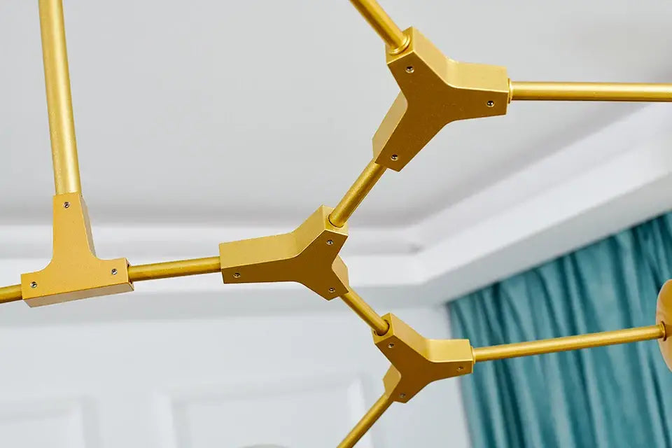 Gold-colored geometric modern chandelier with angular tripod connectors and cylindrical rods stylish nordic chandelier for living room and dining