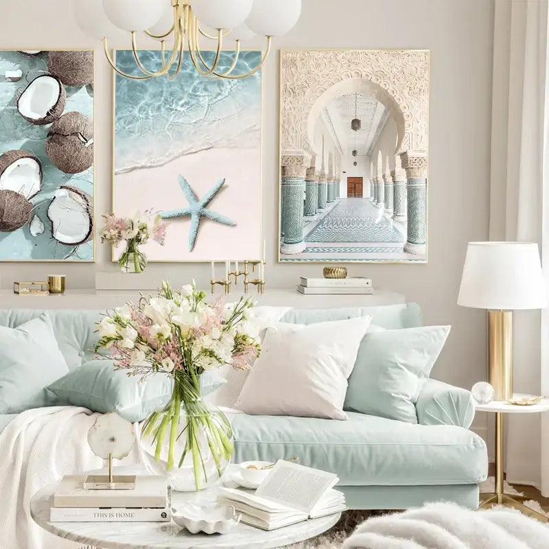 Light blue velvet sofa with white and pale pink throw pillows beside decorbites summer beach seashell canvas wall art