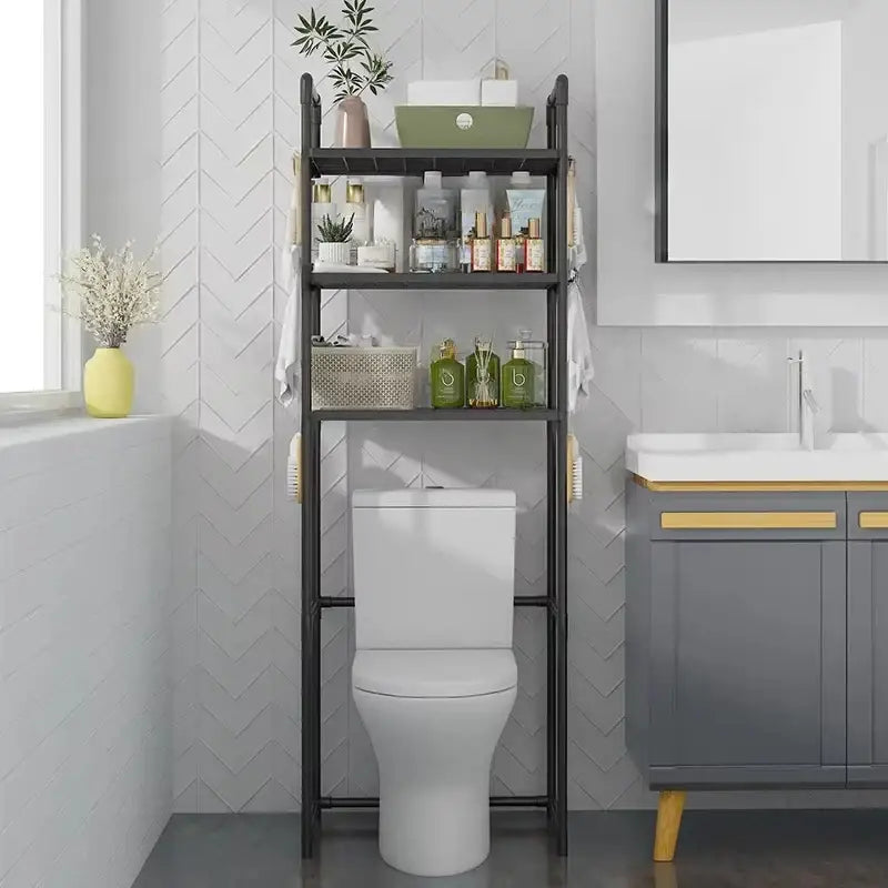 Black metal three-tier over-toilet storage rack with hanging towel racks for bathroom storage by DecorBites