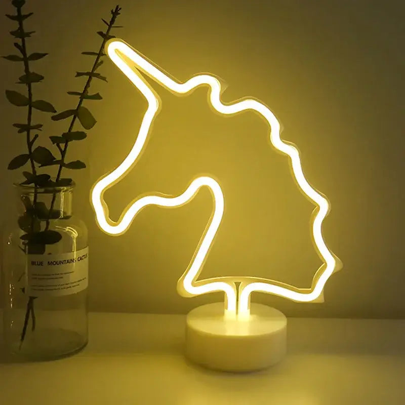 A glowing yellow led neon unicorn head lamp with minimalist design and white circular base for home decoration