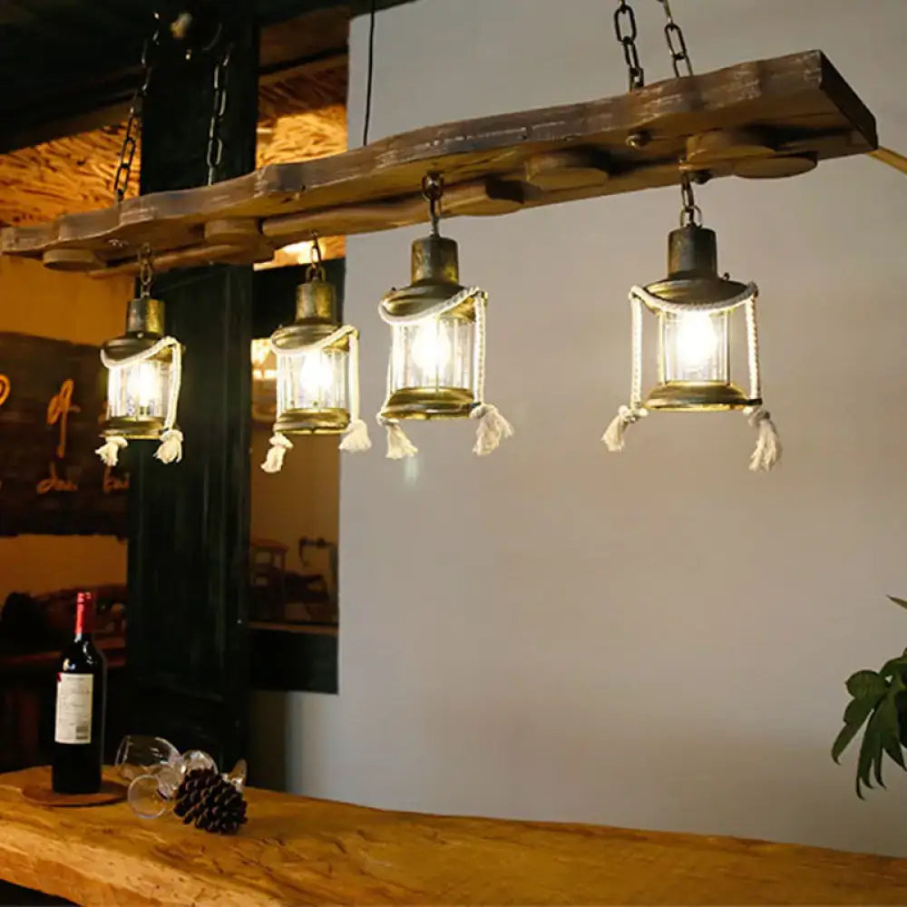 Rustic dark wood island lamp with four brass frame kerosene lights and clear glass panels adorned with white tassels