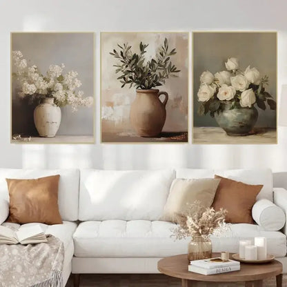 Three framed canvas prints from DecorBites™ featuring rustic ceramic vases with muted earth tone floral arrangements