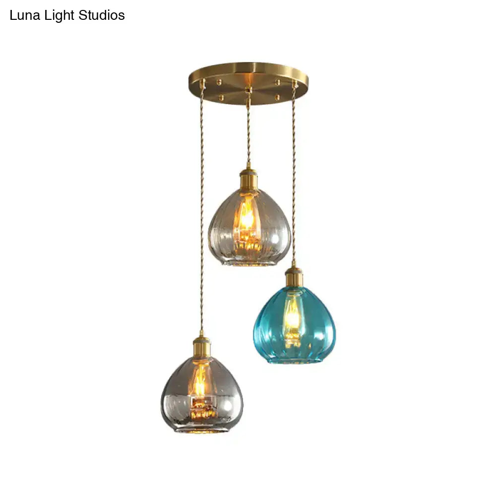 Three pendant glass onion multi ceiling lights with teal and clear teardrop shades and brass chains by decorbites