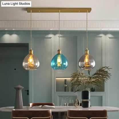 DecorBites vintage glass onion multi ceiling light pendant in brass with tan, blue, and grey glass shades hanging