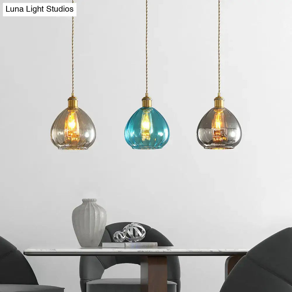 Three glass onion multi pendant lights with brass fixtures in tan blue and grey for vintage multi ceiling light setup