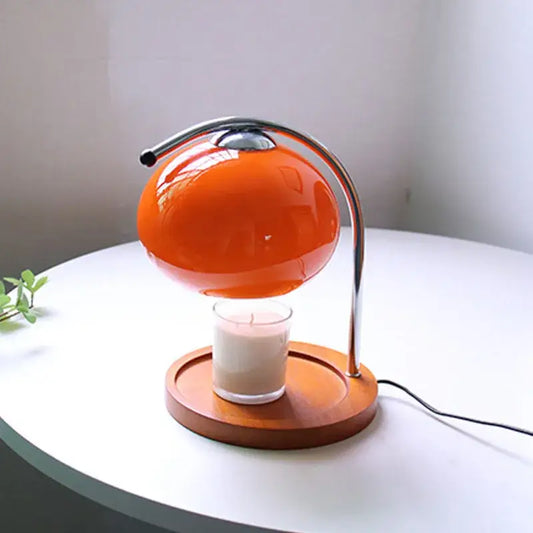 Vibrant orange spherical vintage glass table lamp with chrome stand and wooden base designed to hover above a candle