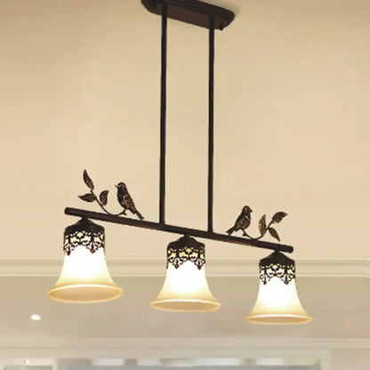 Black wrought iron DecorBites™ pendant light with three handblown glass shades and decorative bird details for dining room