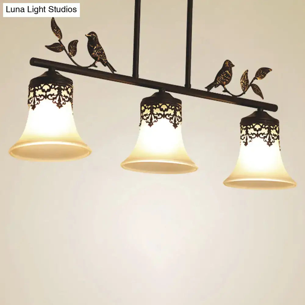 Black wrought iron pendant light with three handblown glass flared shades and decorative bird detail ideal for dining room