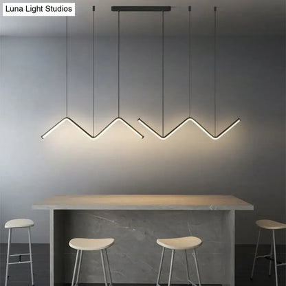 Modern black metal decorbites w-shaped pendant light fixture with zigzag design above minimalist dining bar