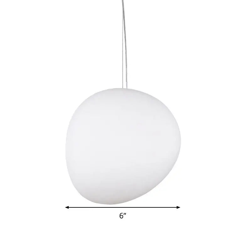 Matte white glass oval pendant light with smooth rounded stone shape and thin metallic cord for ceiling use