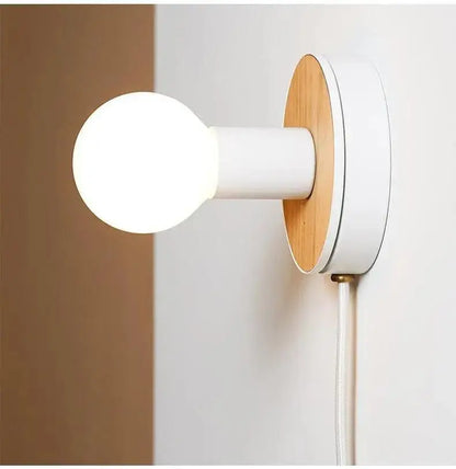 Minimalist decorbites™ wood plug-in wall sconce by bo-ha with white cylindrical stem, wooden backplate, and frosted glass bulb