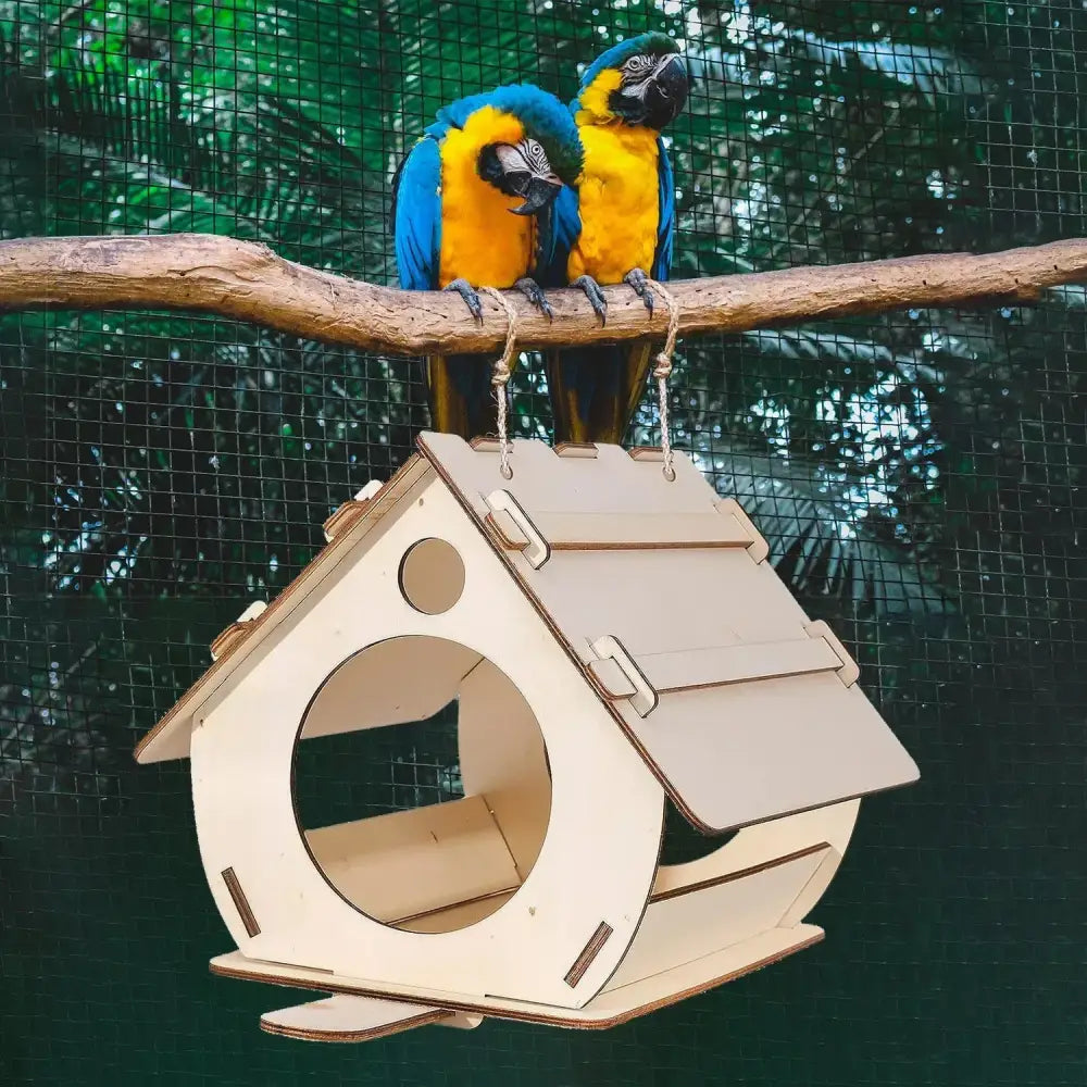A light-colored wooden bird feeder with slanted roof, circular entrance, and hinged side panels for outdoor use