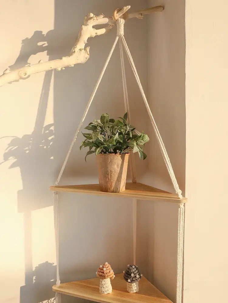Decorbites™ wooden corner shelf with beige macrame and wooden frame holding a potted plant and crocheted mushrooms