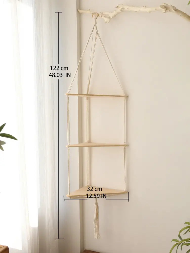 Beige macrame hanging wooden corner shelf with three tiers and tassel for boho wall decor by DecorBites