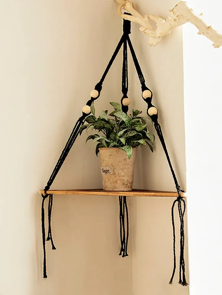 Black macrame wooden corner shelf with wooden slat and light-colored wood beads boho wall decor by DecorBites