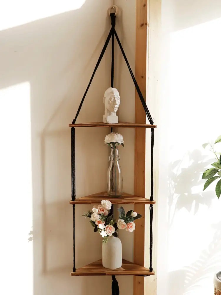 Black macrame cord suspends three wooden triangular shelves in the DecorBites wooden corner shelf boho wall decor