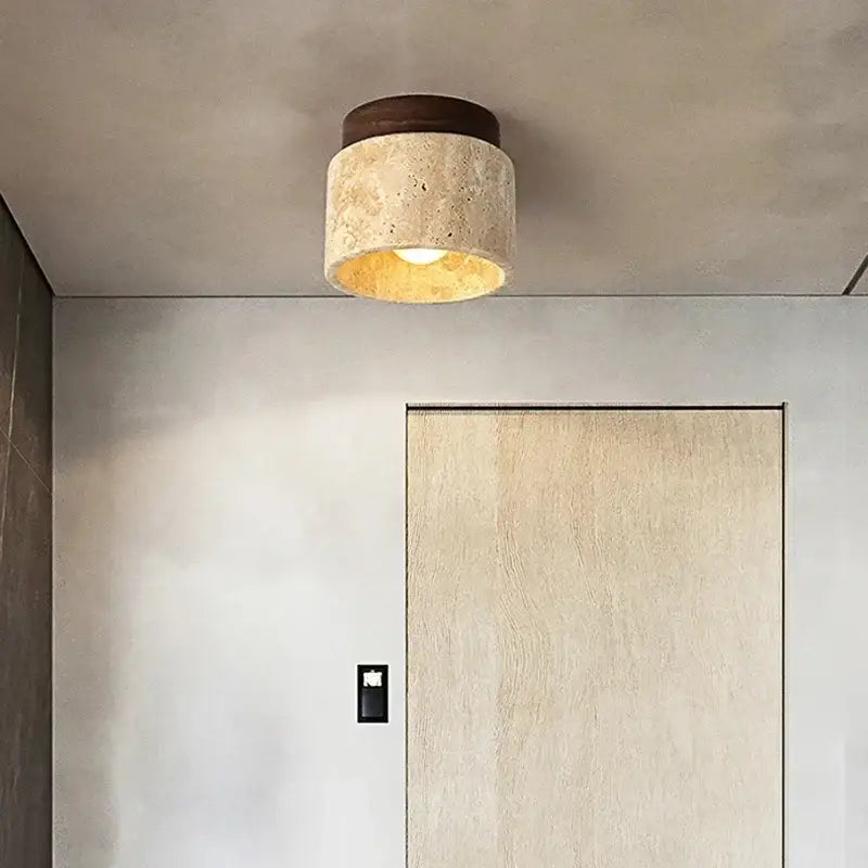 Rounded ceiling light with yellow marble textured stone body and dark wood top emitting warm glow for home or commercial spaces