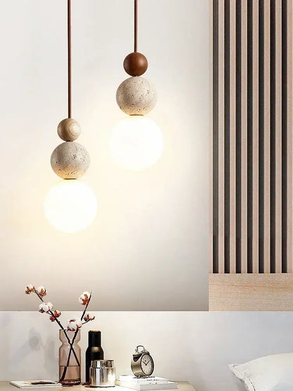 DecorBites™ yellow travertine pendant light featuring stacked spherical stone pendant with bronze accents and warm bulbs