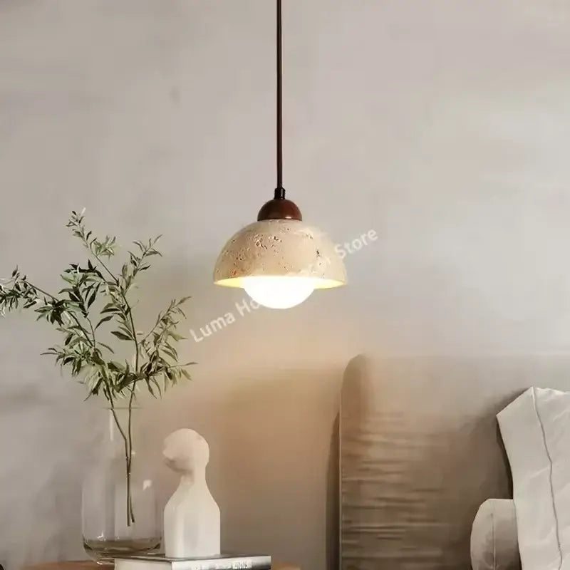 DecorBites™ yellow travertine stone pendant light with warm-toned textured concrete and dark metal chain for kitchen island