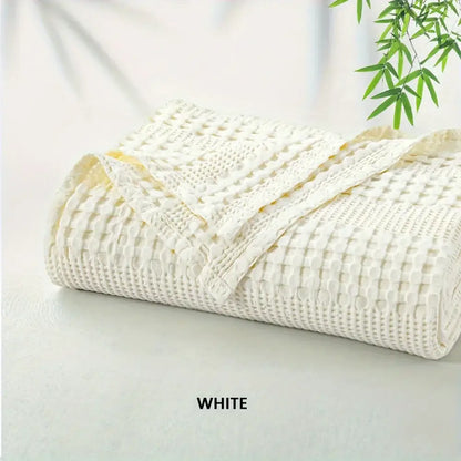 A white bamboo cotton waffle blanket with soft textured surface and neatly folded edges by decorbites bamboo cotton