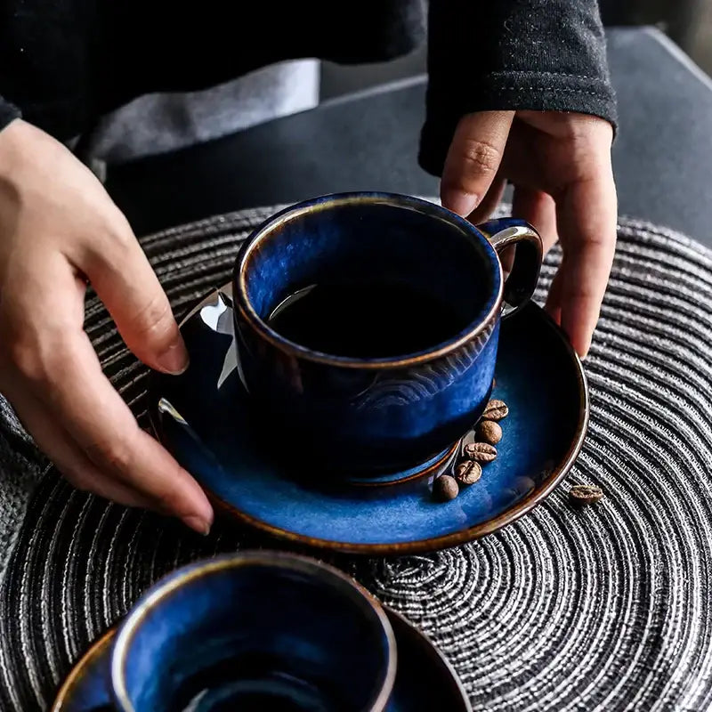 Deep blue glossy ceramic espresso coffee cup with textured glazed finish and matching coffee cup saucer set for dining room