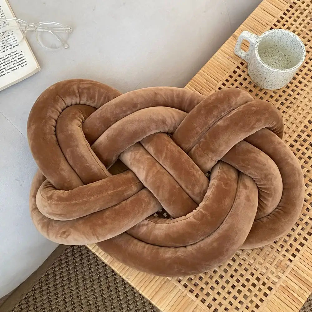 A plush tan-colored velour throw pillow shaped as a knot for decorbites blue handmade knot living room decor