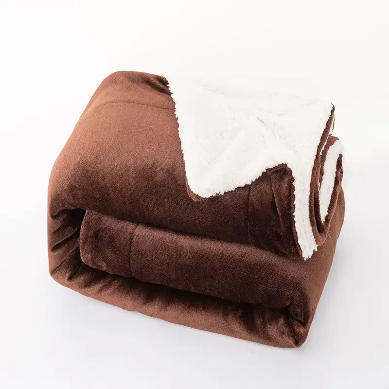 A plush brown and white double-layer lamb fleece blanket folded to show its soft textured outer fabric and cozy fleece interior