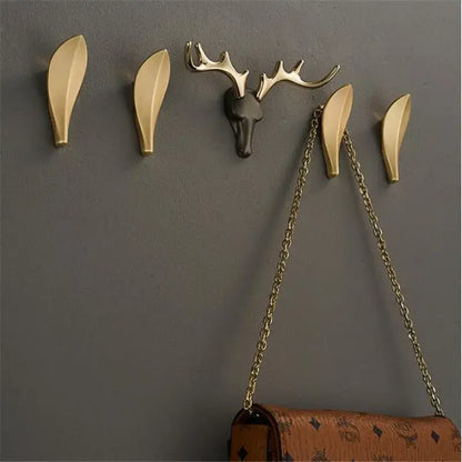 Deer antler gold brass wall mount robe hooks with gold-toned leaf design and matte black antler centerpiece decorbites brass wall