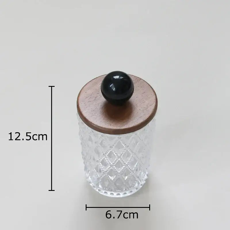 Clear glass jewelry jar with diamond pattern and walnut lid topped by glossy black colorful ceramic ball knob for storage
