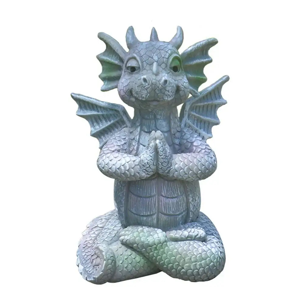 A gray dragon dino garden sculpture with green-tinted wings and eyes meditating for fun dinosaur decorbites dino garden decor