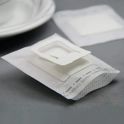 Disposable coffee filter cup with white paper bag, clear plastic insert, and perforated edges for filter cup drip use