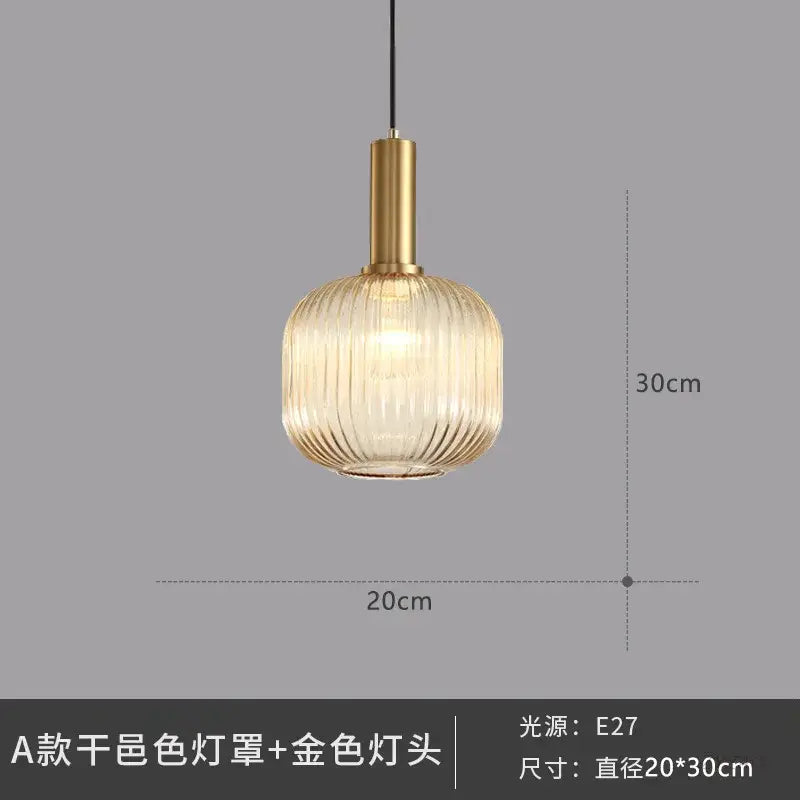 Elegant amber ribbed glass pendant lights with translucent shade and gold-toned metal fixture for dining room use