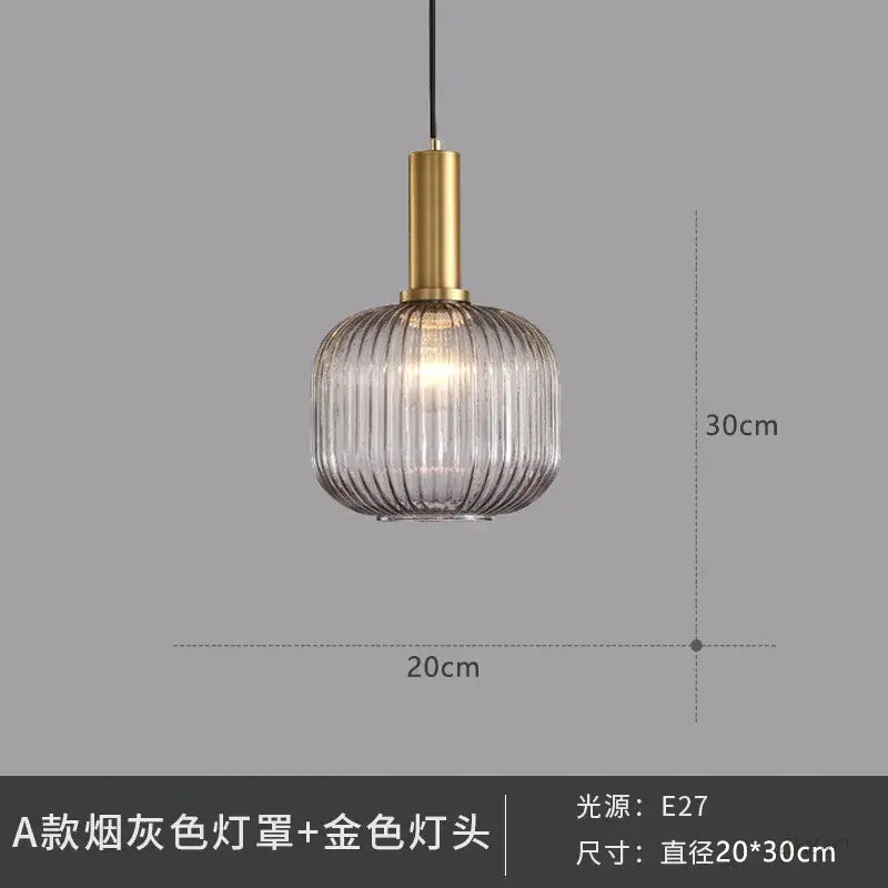Elegant smoked gray glass pendant light with vertical ridges and gold-toned metal fixture for dining room lighting