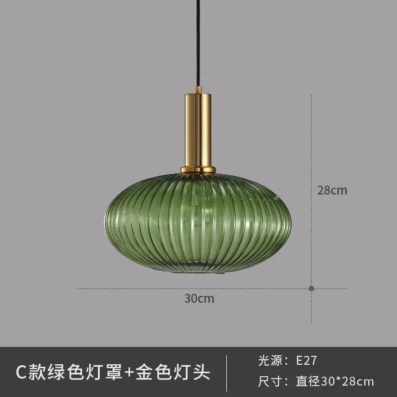 A sleek green ribbed glass pendant light with polished gold metal fixture ideal for elegant dining room lighting