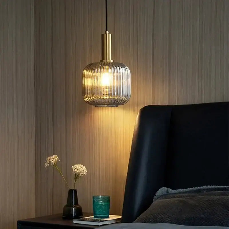 Elegant amber glass pendant lights featuring a warm-toned brass stem and ribbed translucent shade for dining rooms
