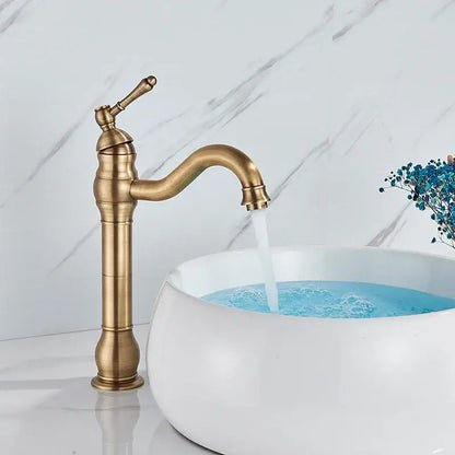 Antique brass finished single handle sink faucet with curved spout and ornate detailing for bathroom use
