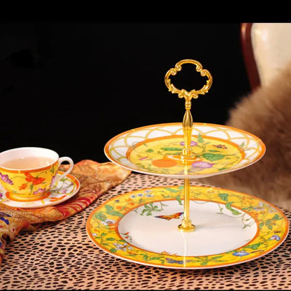 Two-tiered dessert stand with ornate gold handle and yellow floral porcelain plates from butterfly kitchen tableware set